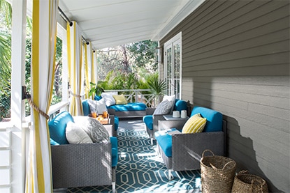 Patio couvert gris avec plafond blanc et mobilier de jardin gris assorti aux coussins bleus. Patio couvert gris avec plafond blanc et mobilier de jardin gris assorti aux coussins bleus.