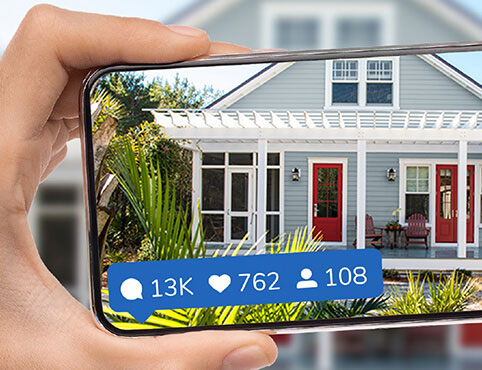 Phone taking a picture of a home exterior for social media.